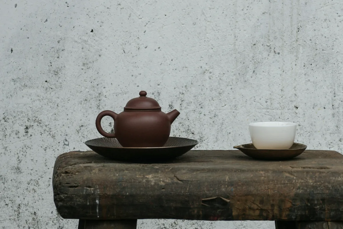 Théière en terre cuite et petite tasse posées sur un bloc de pierre